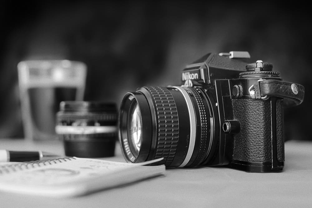 black Nikon DSLR camera on white surface