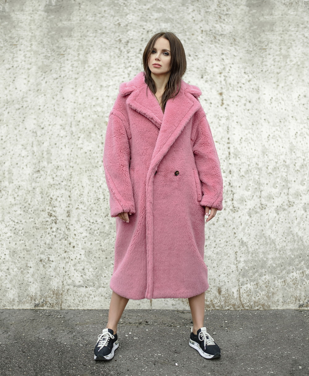 mulher em pé enquanto usa casaco rosa