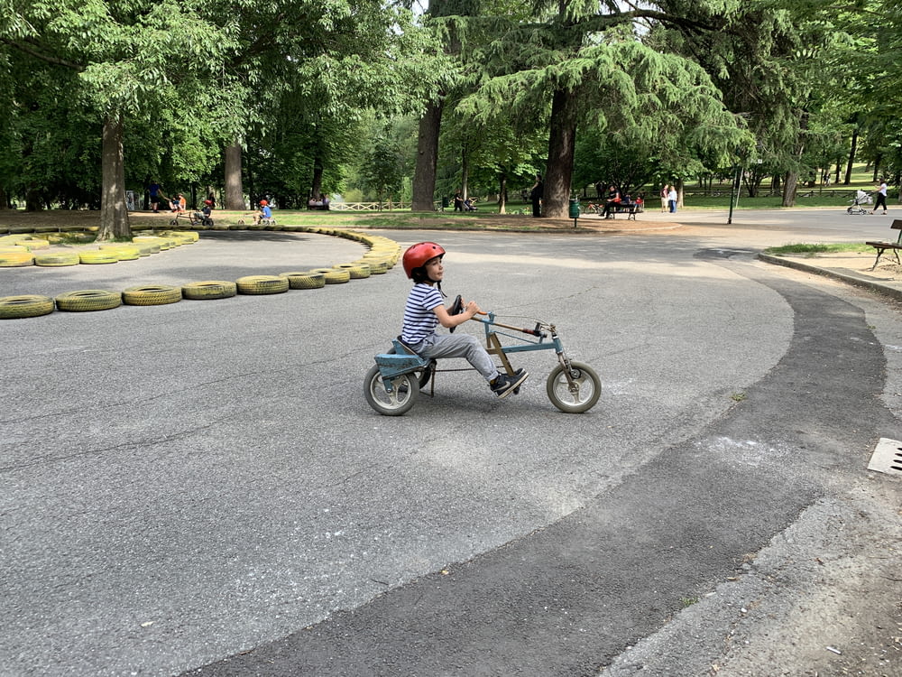 child riding on trike on park