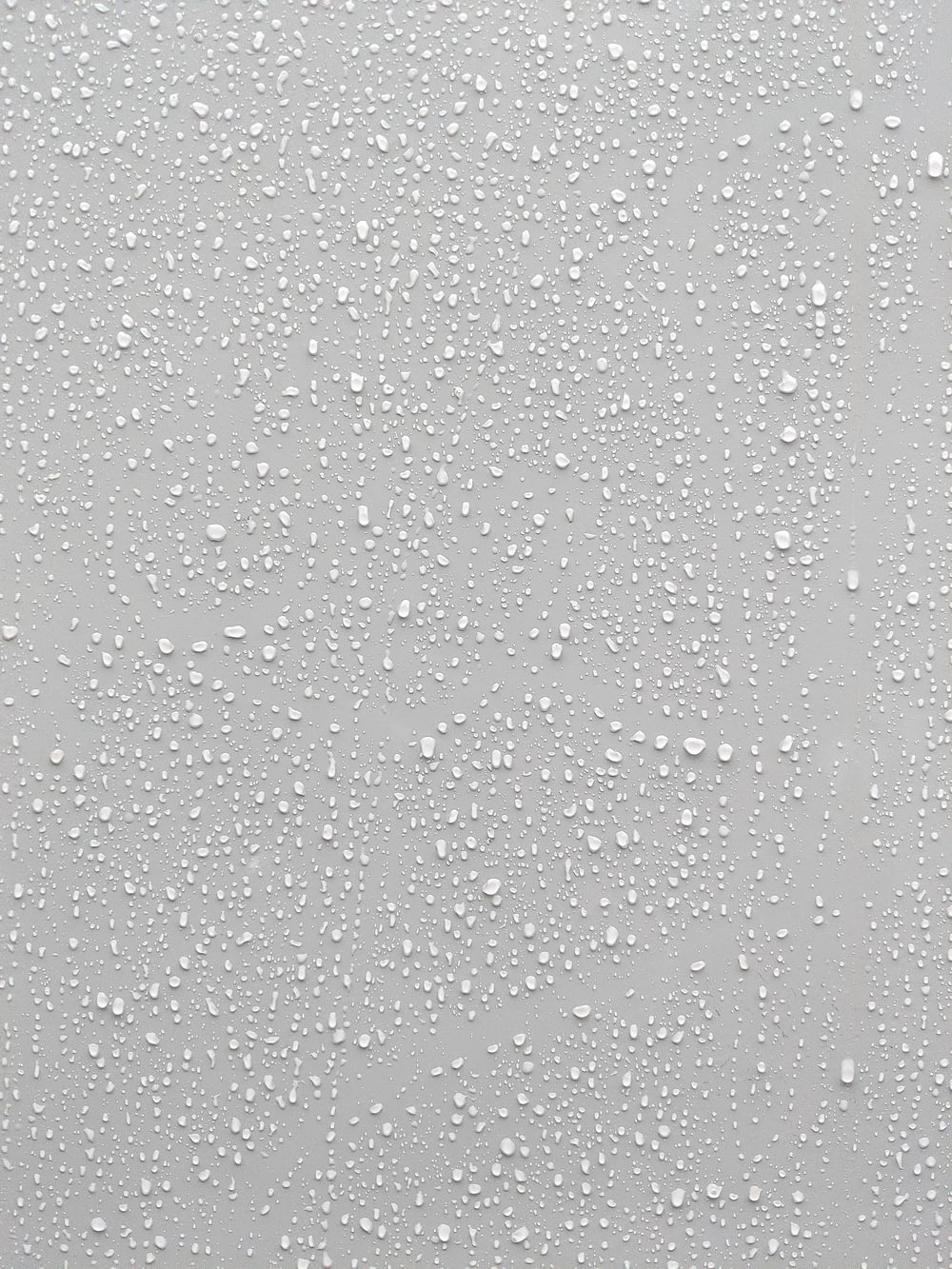 Wassertropfen auf eine Glasoberfläche mit weißem Hintergrund