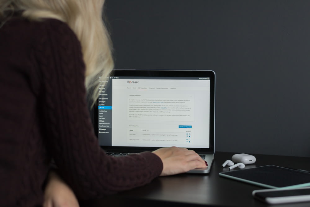 Mujer con suéter negro usando MacBook Pro