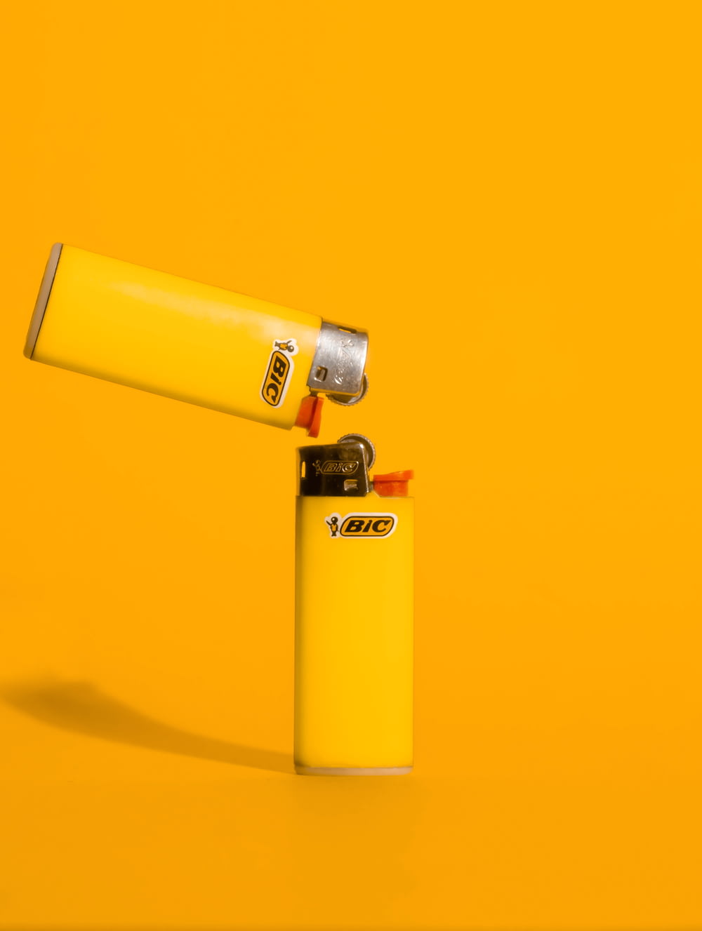 a yellow lighter sitting on top of a yellow surface