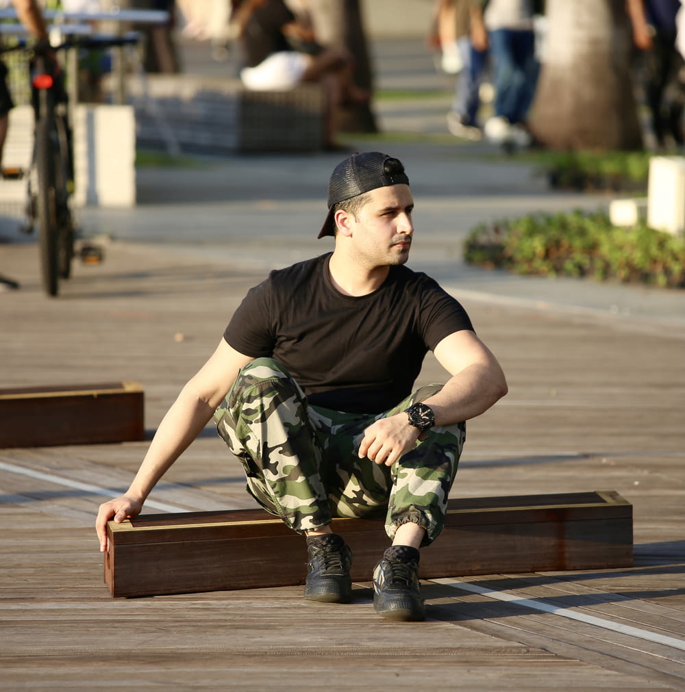 a man sitting on a wooden bench in a park