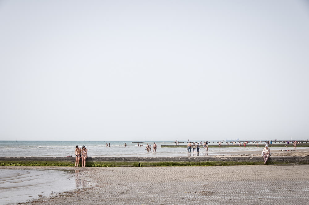 several people walking on seashore
