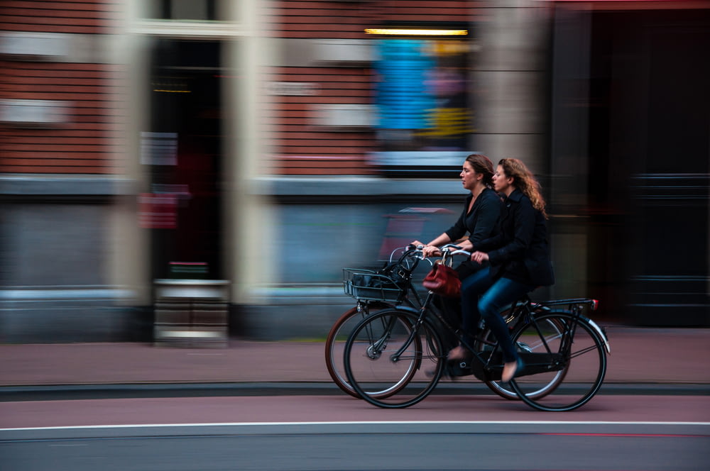 Fotografía de lapso de tiempo de dos personas montando bicicleta