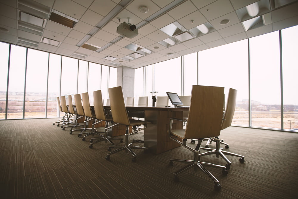 Table et chaises de conférence ovales en bois brun à l’intérieur de la salle de conférence
