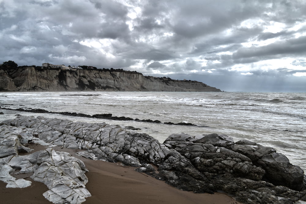 rocce grigie vicino al mare sotto il cielo grigio