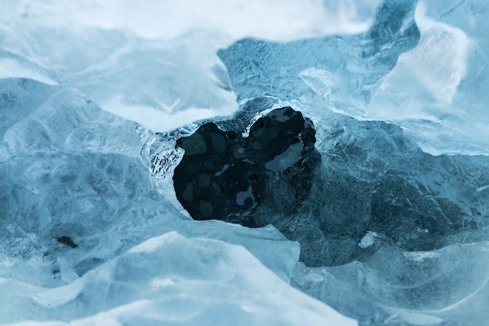 Un agujero en una capa de hielo que cubre agua azul oscuro