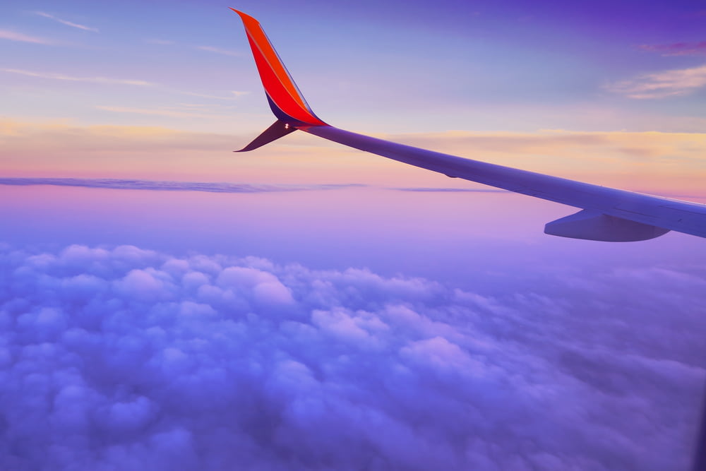 Persona en un avión que vuela a gran altitud tomando foto del ala izquierda del avión durante el día