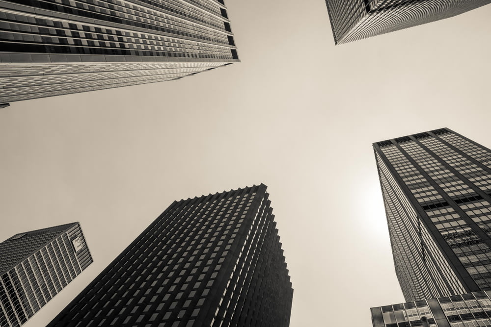 low angle and grayscale photography of high-rise buildings