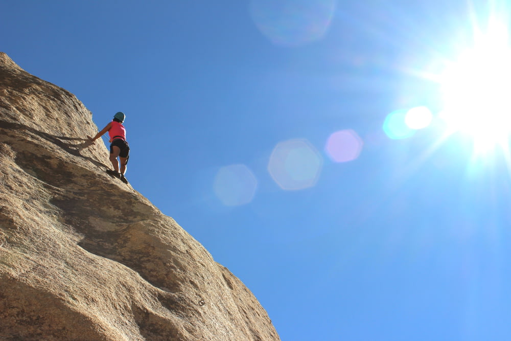 Persona escalada en roca durante el día