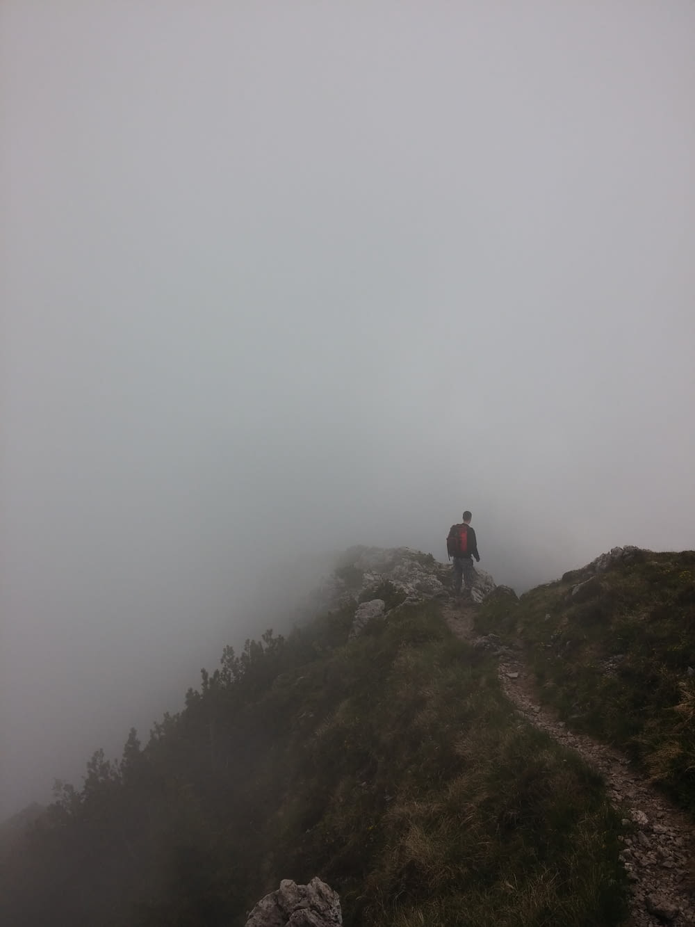 Mann, der auf einem Hügel mit Nebel steht