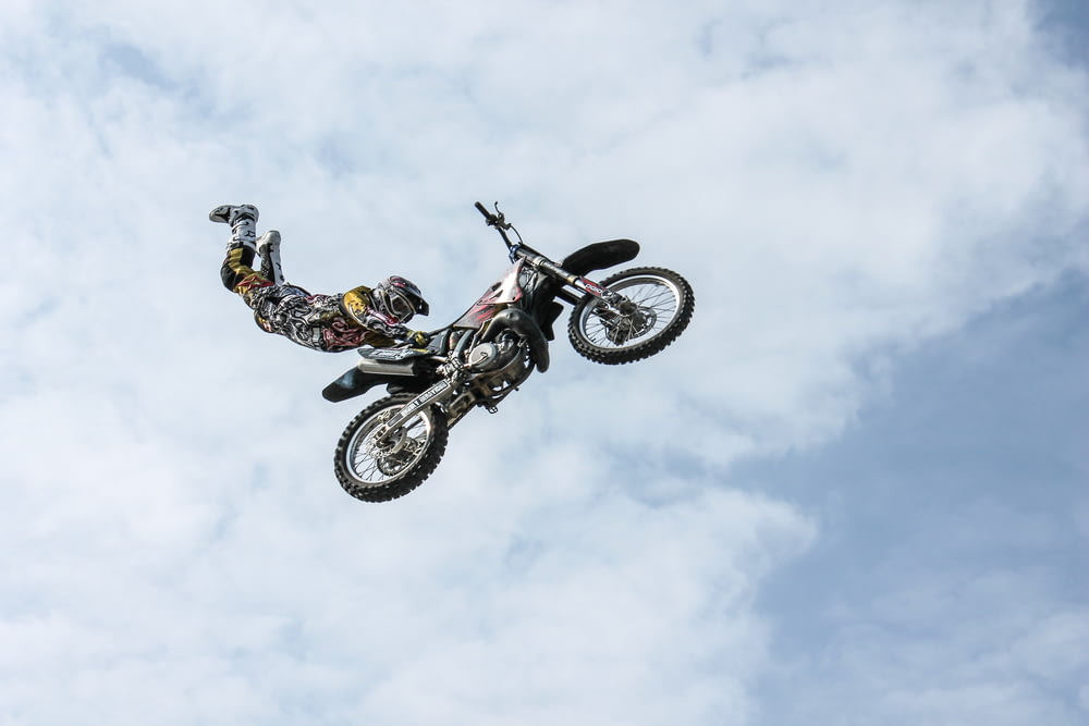 fotografia de baixo ângulo do jogador de motocross realizando motocross voando estilo
