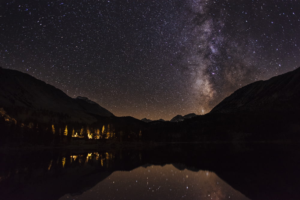 mountain reflecting on body of water at nighttime