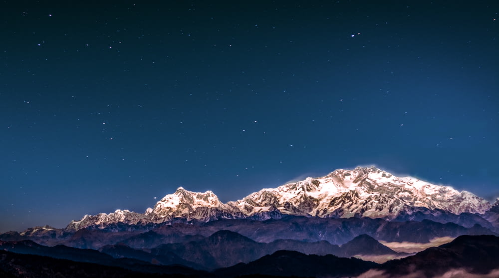 snow covered mountain under starry sky