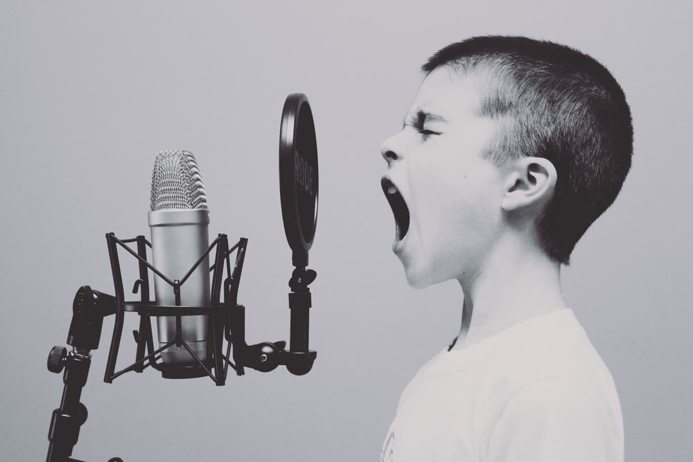 menino cantando no microfone com filtro pop