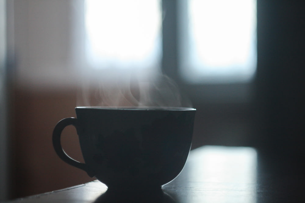 xícara de chá de cerâmica preta na mesa