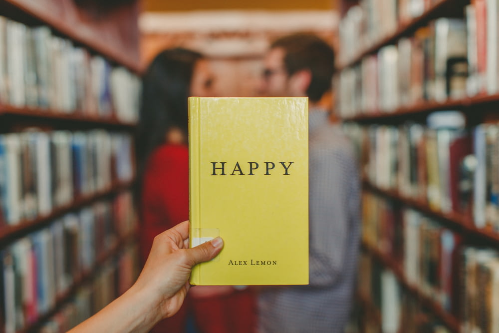 Person, die das Buch "Happy" von Alex Lemon in der Hand hält
