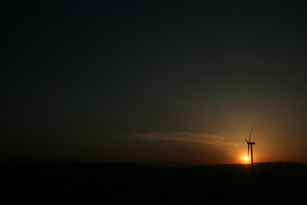 silhouette of windmill under golden hour
