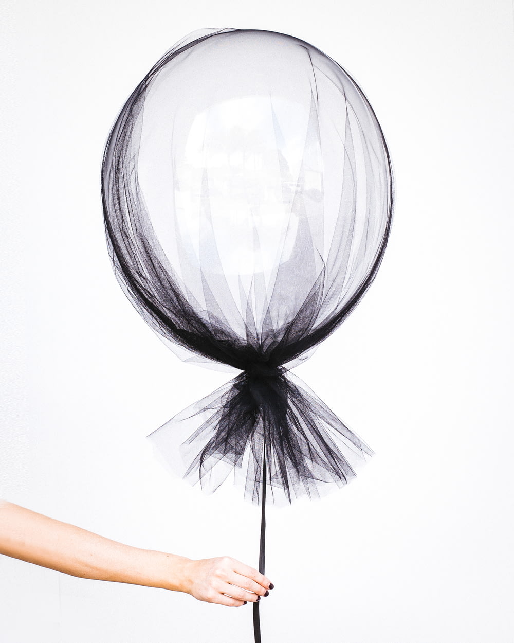 person holding black balloon decal