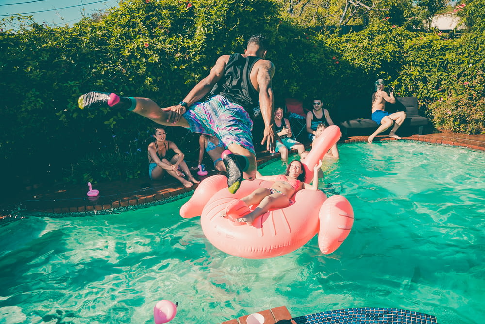 A man diving into a pool at a party.