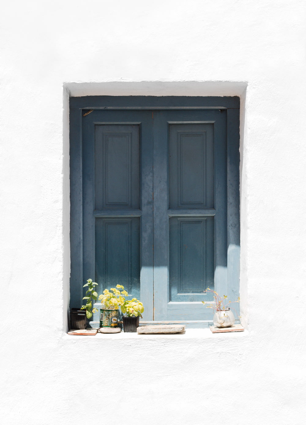 puerta de madera azul sobre pared de hormigón blanco