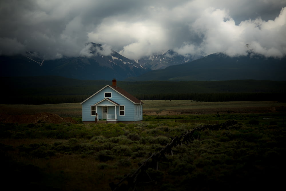 maison sur champ d’herbe sous ciel gris