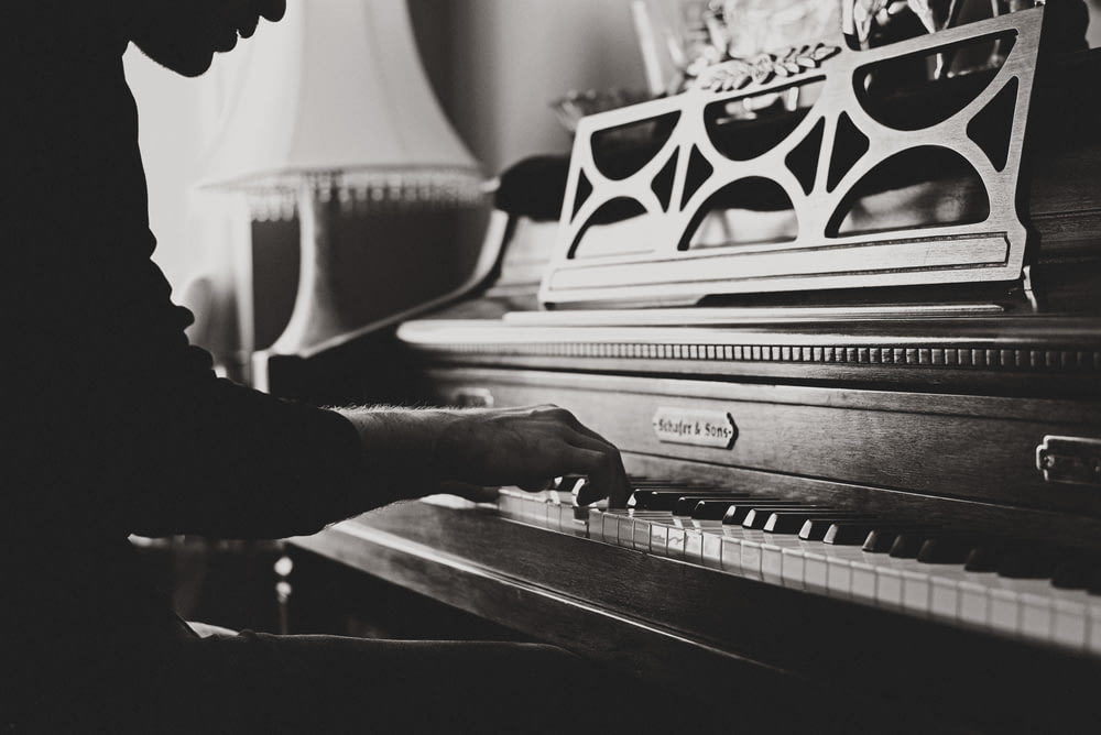 그레이 스케일 사진 의 남자 연주 spinet piano 클로즈업 사진