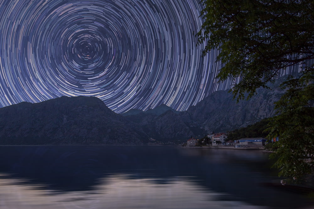 bodies of water near mountain at starry night