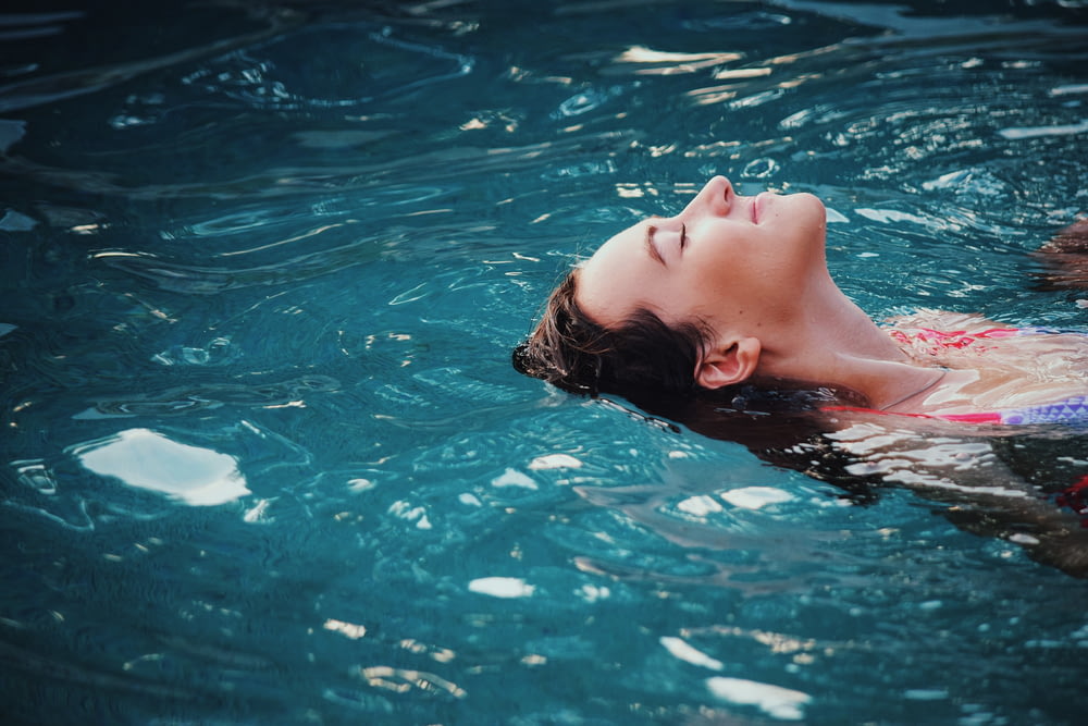 mulher flutuando no corpo da água