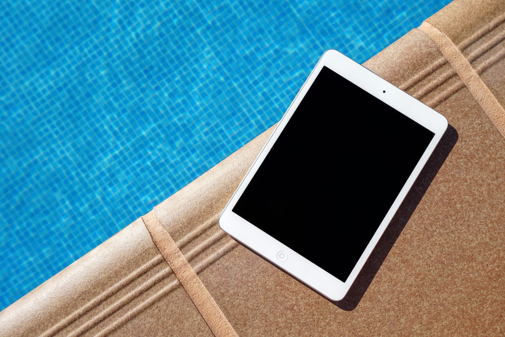 weißes iPad neben Schwimmbad