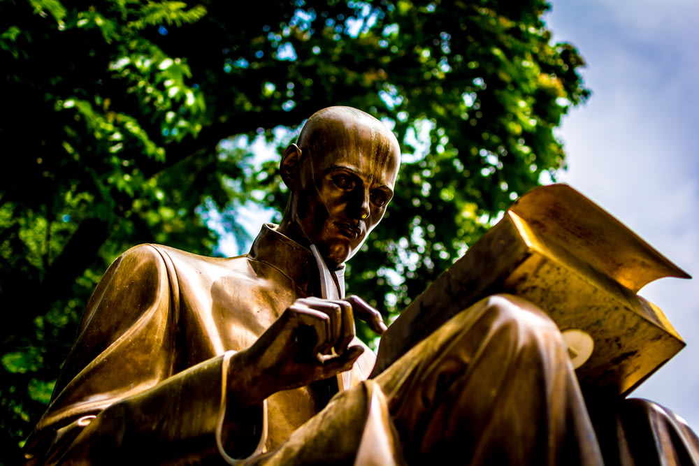 bronze man reading book statue