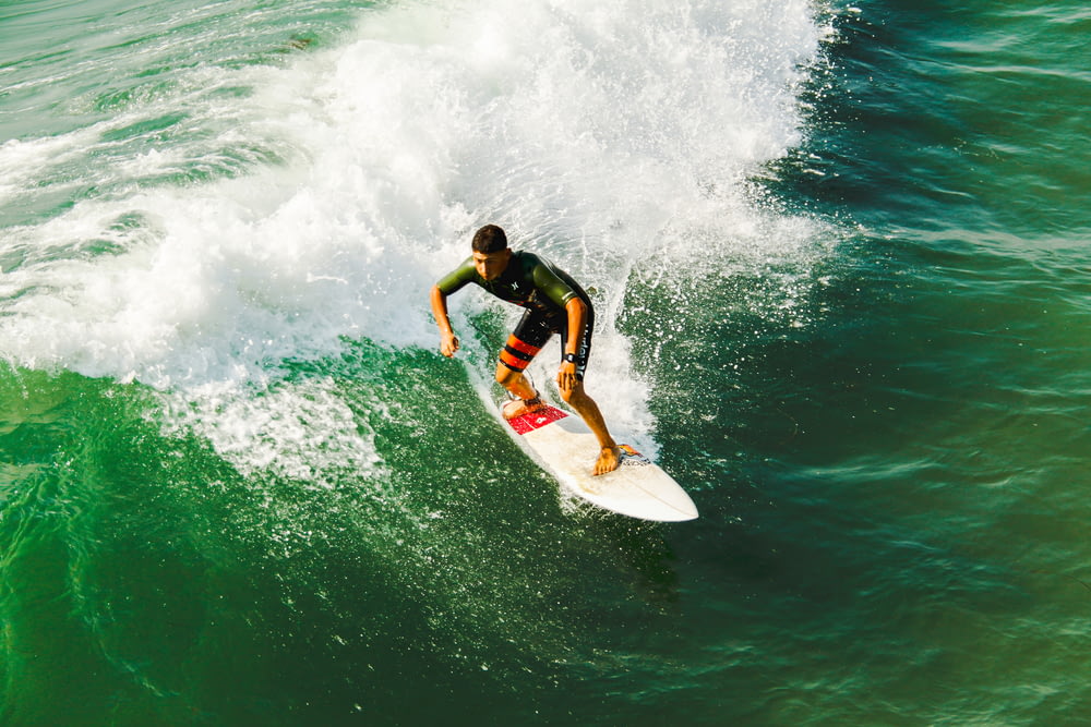 Mann auf Surfbrett surft gegen Wellen