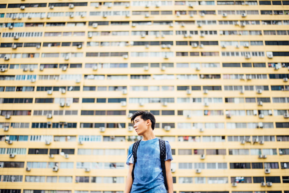 hombre de pie frente a un rascacielos
