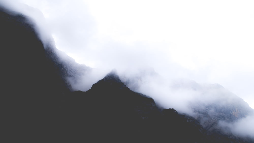 Silhouette eines Berges, der tagsüber mit Nebel bedeckt ist