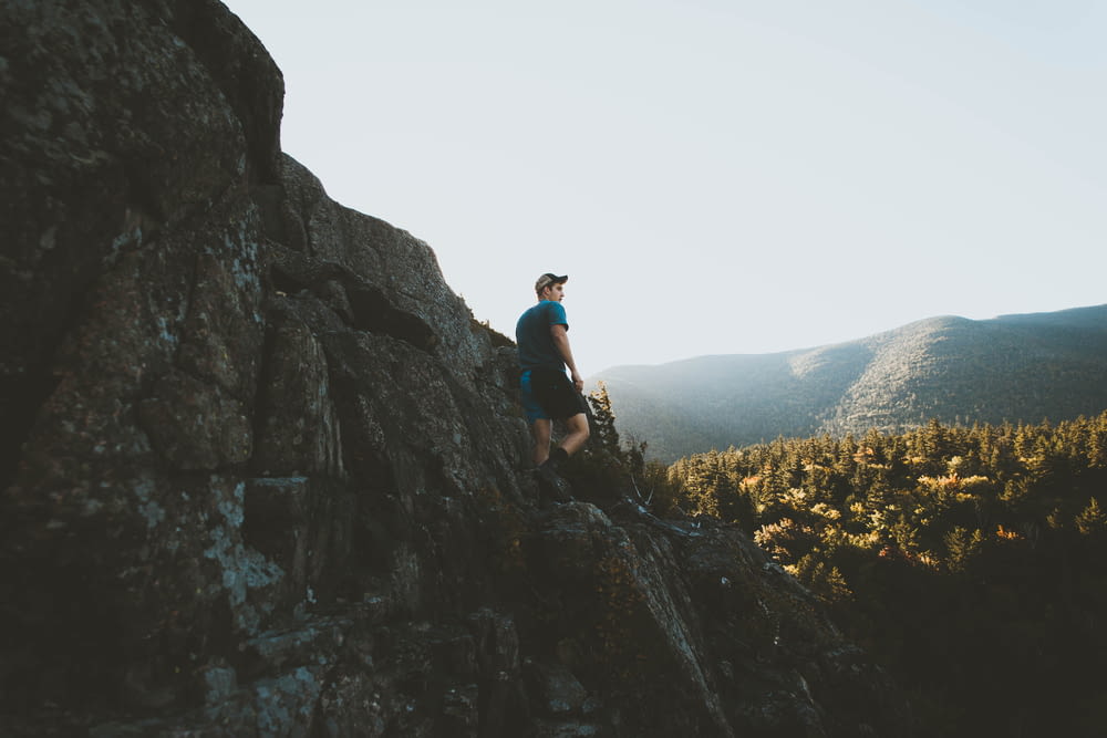 man standing on mountain cliff