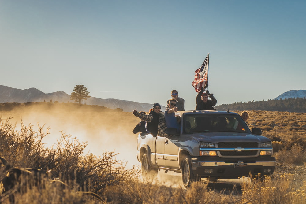 group of people riding silver Chevrolet extended cab
