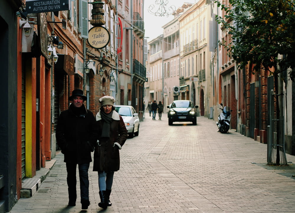 a couple of people walking down a street