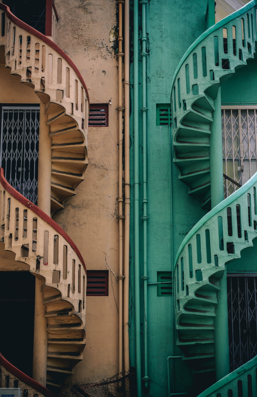 escaleras de caracol de hormigón beige y verde al lado del edificio