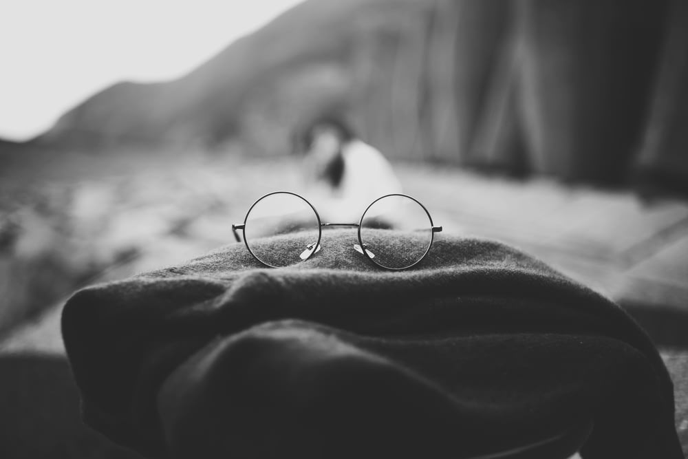Foto en escala de grises de gafas hippies sobre tela