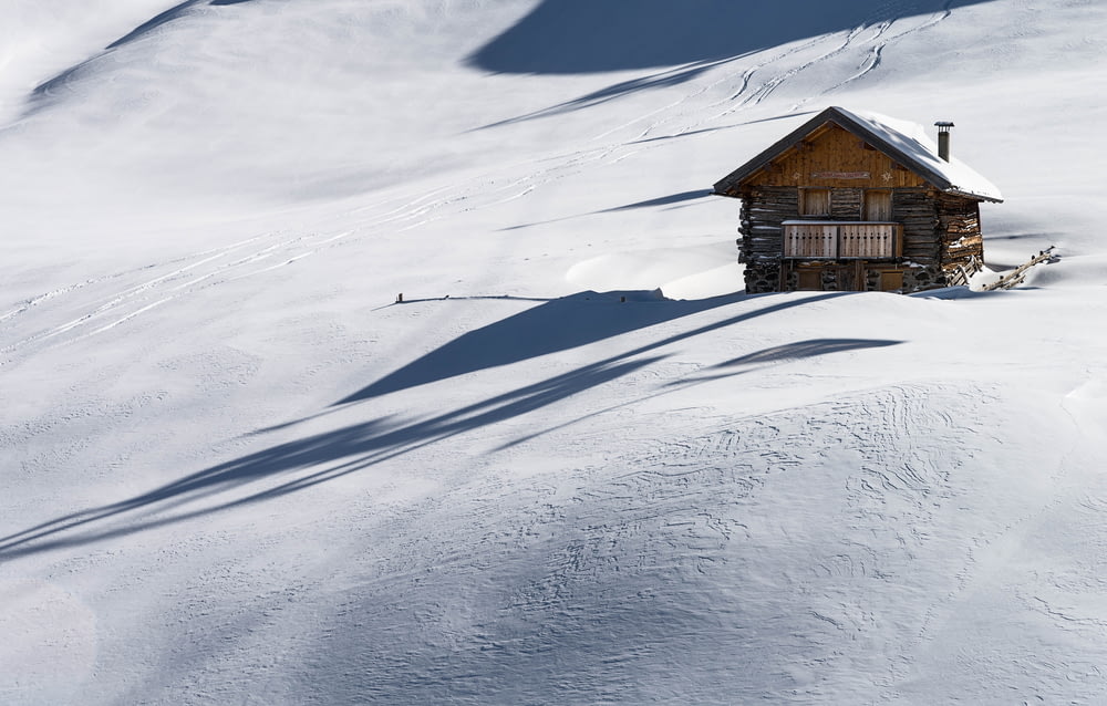 casa de madeira marrom coberta de neve