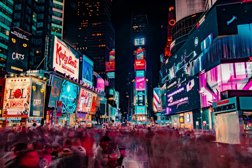 fotografia time-lapse de multidão de pessoas na praça Time de Nova York durante a noite