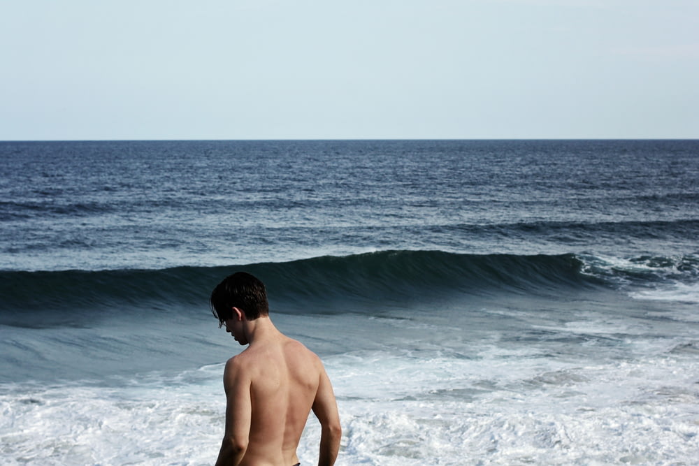 homem em pé na frente do oceano