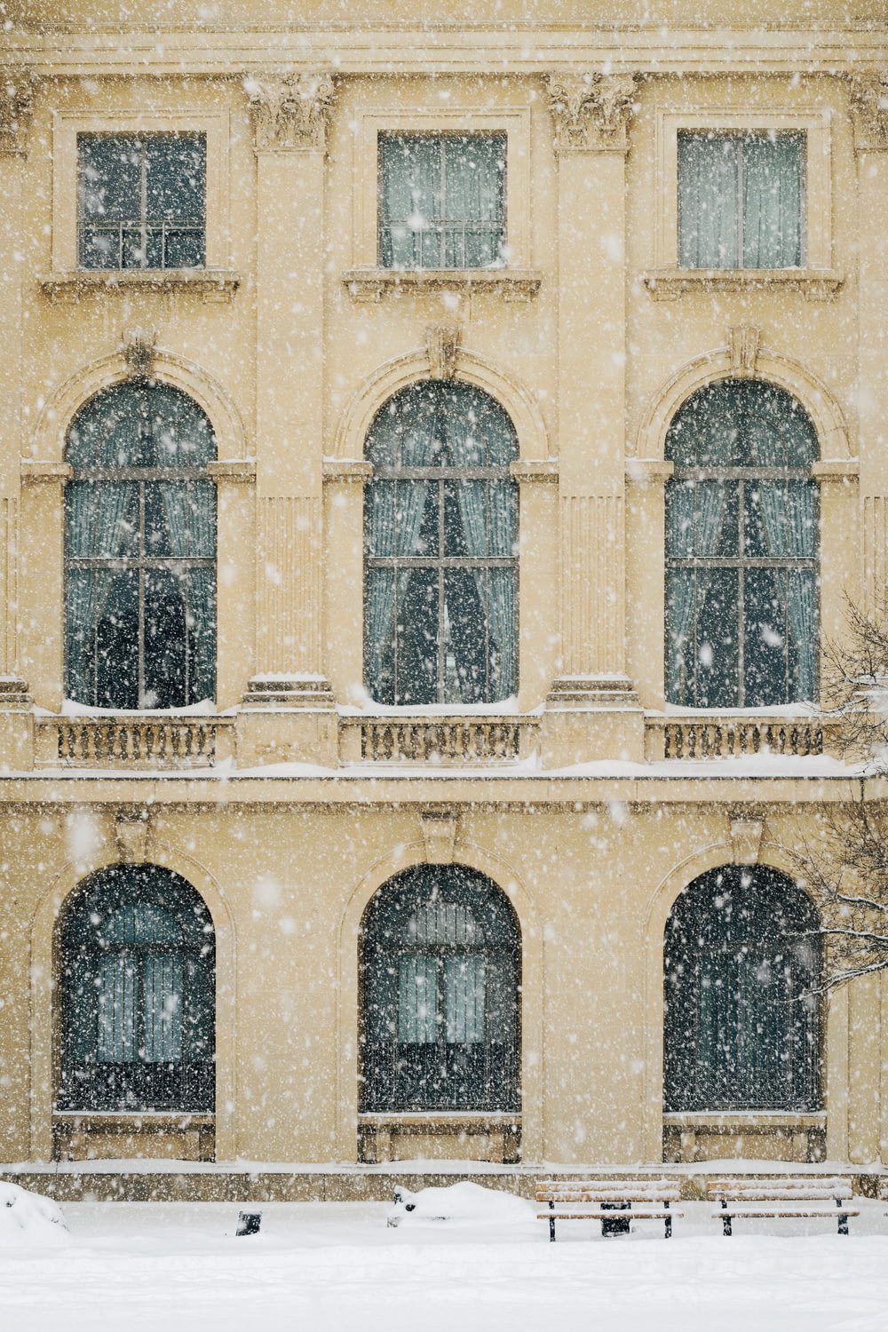 photo of beige concrete 3-storey building with snow