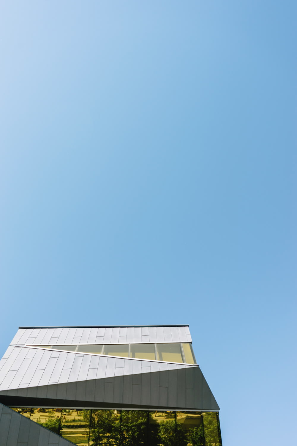 fotografia ad angolo basso di un edificio in cemento bianco sotto il cielo azzurro