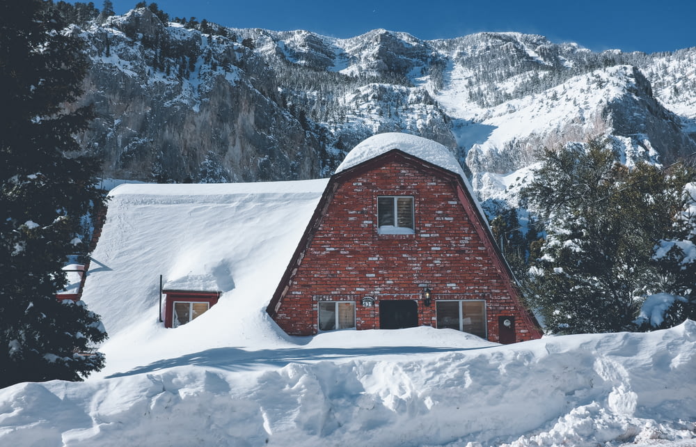 photo of brown brick house covered with snow