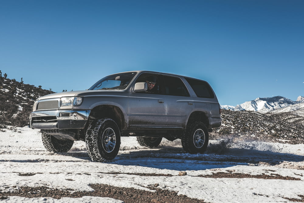 silver SUV on snow mountain