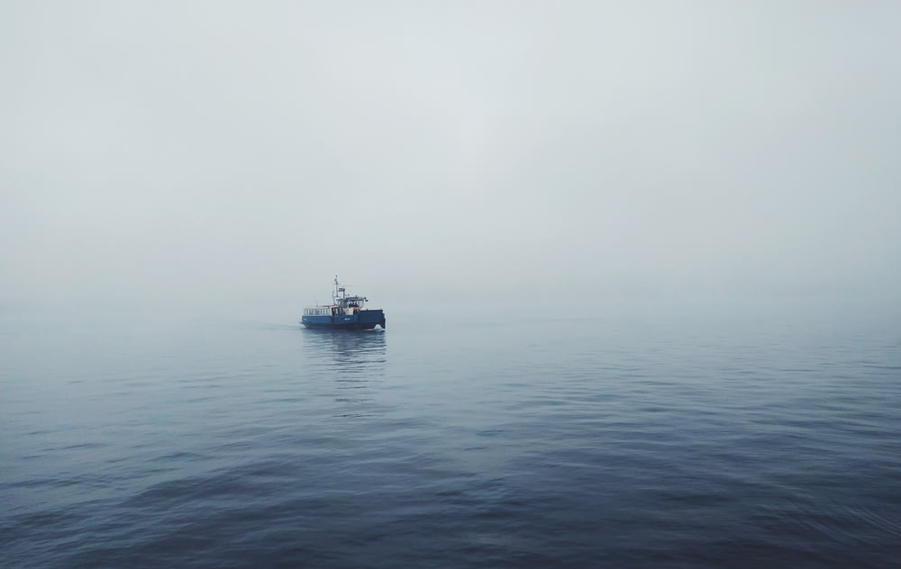 foto de foco do barco de pesca preto no corpo da água