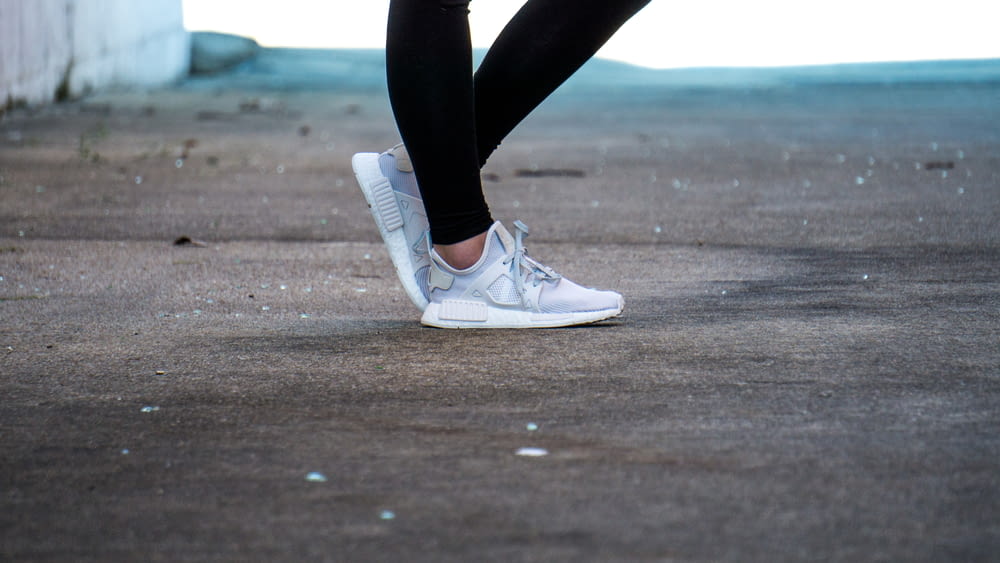 Foto de enfoque superficial de una persona que usa zapatos grises para correr