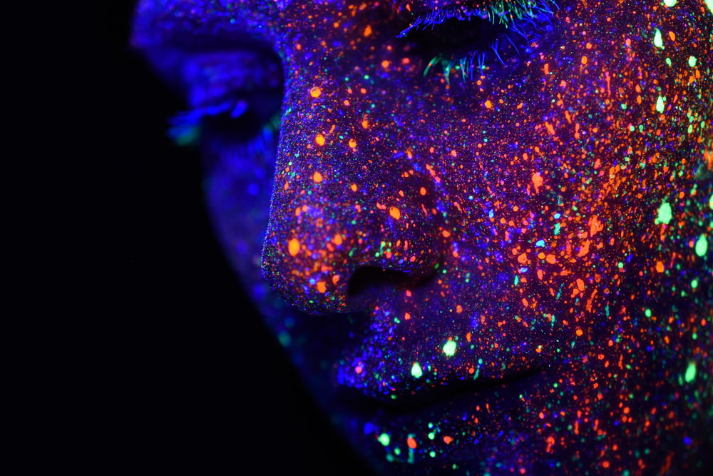 Persona con pintura de colores variados en la cara